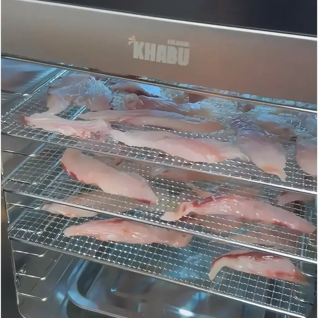 Fish fillets laid on stainless steel trays inside a Kalahari Khabu Biltong Boss